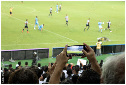 Man recording a soccer match on Brazil with his mobile phone