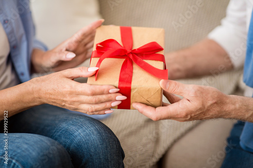 Present of love. Senior couple sharing holiday gift