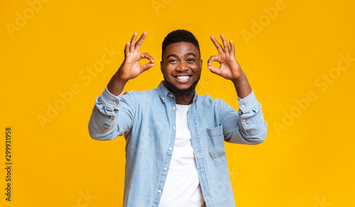 Optimistic african american guy showing ok gesture with both hands