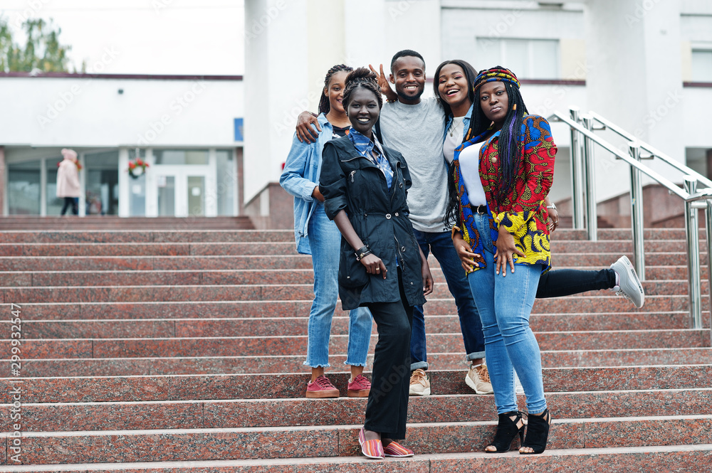Group of five african college students spending time together on campus at university yard. Black afro friends studying. Education theme. - obrazy, fototapety, plakaty 