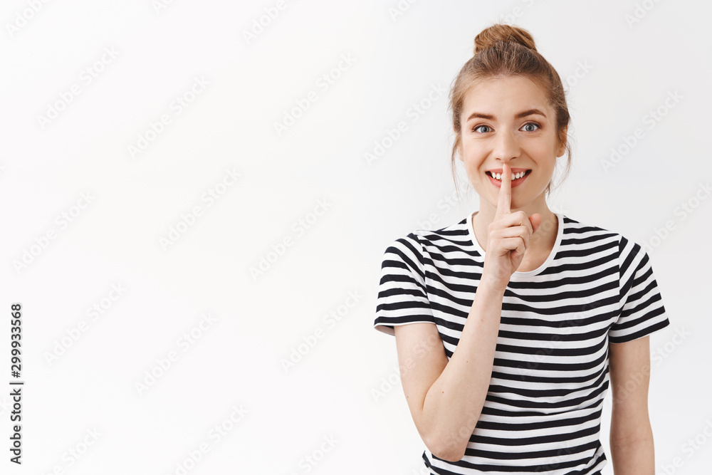 Cheerful girl prepare surprise asking not tell anyone, shushing and smiling excited, press finger to lips and gazing camera, need you stay quiet, make shhh gesture, standing white background Cheerful girl prepare surprise asking not tell anyone, shushing and smiling excited, press finger to lips and gazing camera, need you stay quiet, make shhh gesture, standing white background