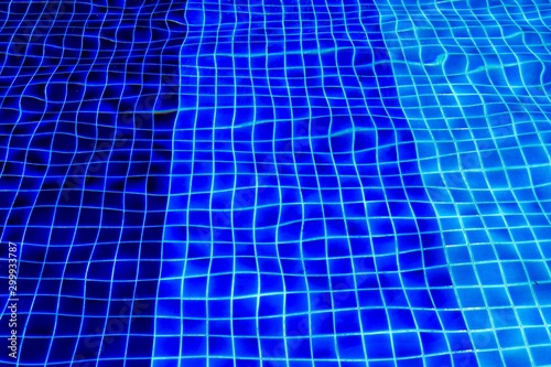 Various blue tile on the bottom of swimming pool, Ripple and wave on water surface and under.
