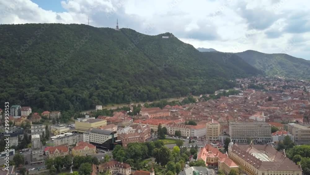 Aerial view of Brasov city, medieval town situated in Transylvania, Romania. Old architecture surrounded with big Carpathian mountains covered with dense green forest. Aerial view of Brasov city, medieval town situated in Transylvania, Romania. Old architecture surrounded with big Carpathian mountains covered with dense green forest.