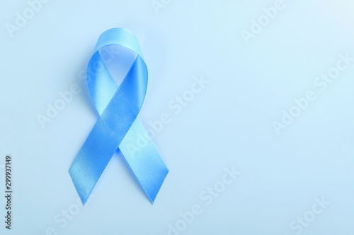 Blue ribbon on blue background, prostate cancer awareness concept. Copy space for text