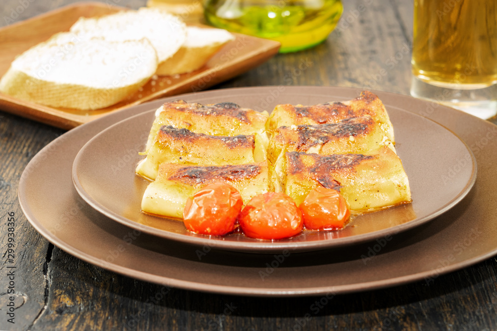 Just cooked pasta cannelloni in rustic stye on the wooden table. Side view. Just cooked pasta cannelloni in rustic stye on the wooden table. Side view.