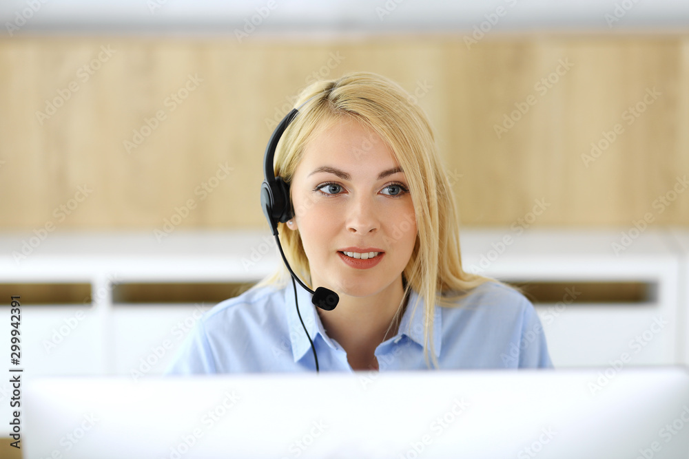Call center. Blonde business woman sitting in headset at customer service office. Concept of telesales business or home office occupation Call center. Blonde business woman sitting in headset at customer service office. Concept of telesales business or home office occupation