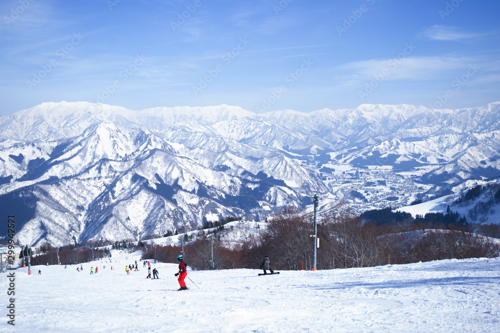 Skier skiing downhill during sunny day in high mountains, Yuzawa Niigata Japan.