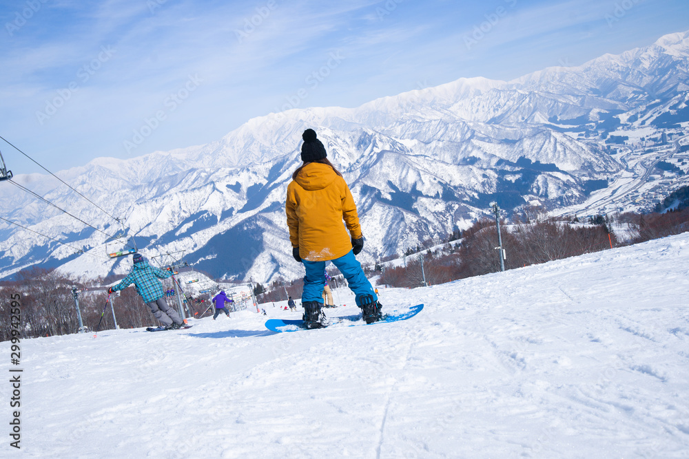 Skier skiing downhill during sunny day in high mountains, Yuzawa Niigata Japan.