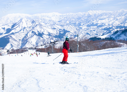 Skier skiing downhill during sunny day in high mountains, Yuzawa Niigata Japan.