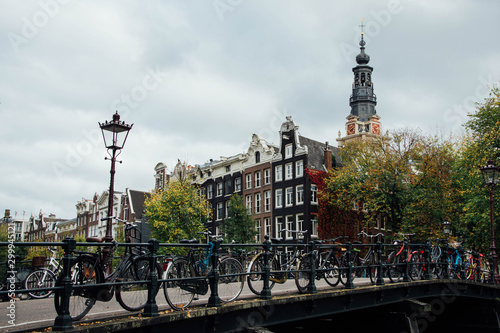 Amsterdam canal with typical dutch houses. Netherlands autumn cityscape. Bicycles.