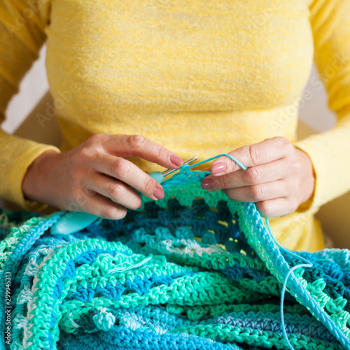 Close-up of female hands knitting. Woman crochets.