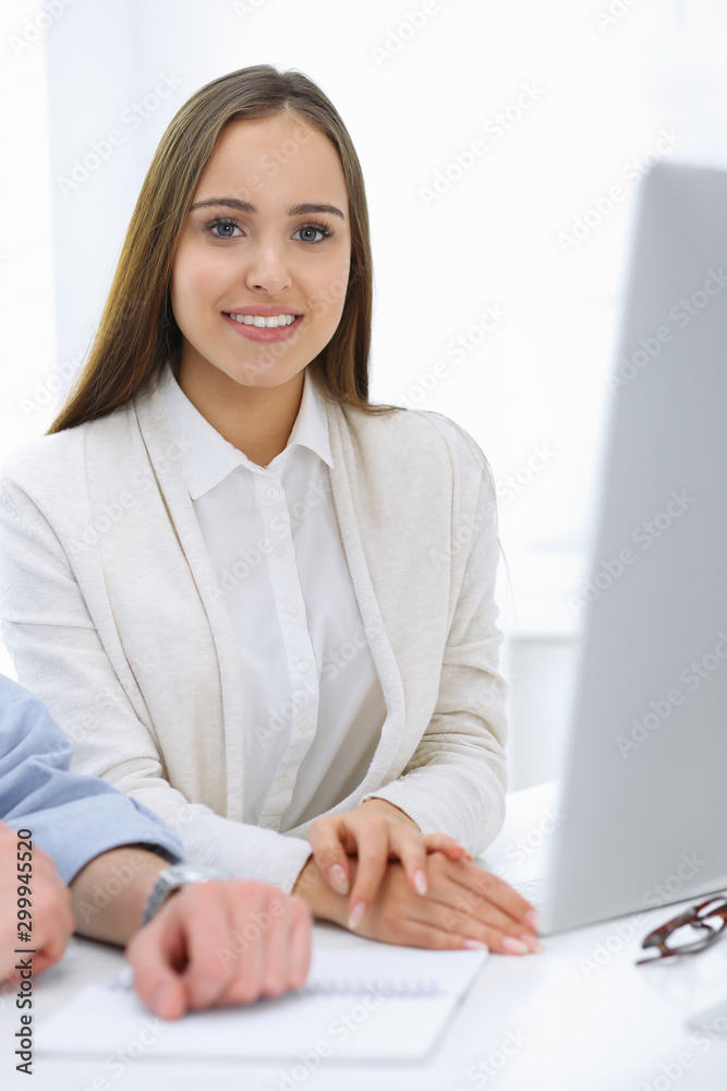 Business woman and man sitting and working with computer in office. Colleagues discussing something at meeting. Corporate teamwork and partnership concepts Business woman and man sitting and working with computer in office. Colleagues discussing something at meeting. Corporate teamwork and partnership concepts