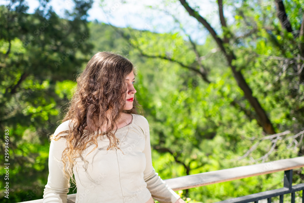 Naklejka premium Young woman leaning on railing fence in modern luxury outdoor spring garden in backyard porch of home in zen house
