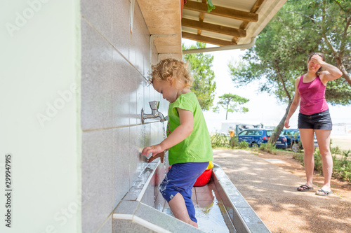 Little girl playing with water and opening a pipe. photo