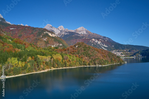 Aerial view of Lake Molveno, north of Italy. In the background Alps, blue sky. Autumn season. Multi-colored palette of colors