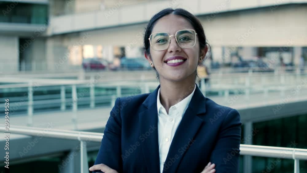 Confident attractive businesswoman smiling at camera. Portrait of beautiful cheerful young businesswoman in formal wear standing with crossed arms and smiling at camera. Business concept Confident attractive businesswoman smiling at camera. Portrait of beautiful cheerful young businesswoman in formal wear standing with crossed arms and smiling at camera. Business concept