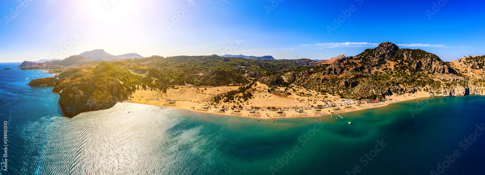 panorama of the famous resort beach tsampika with rows of sunbeds and umbrellas, view of the mountains, the island from a bird's eye view, from drone