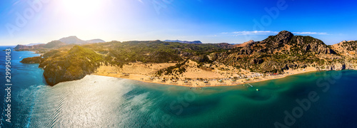 Fototapeta Naklejka Na Ścianę i Meble -  panorama of the famous resort beach tsampika with rows of sunbeds and umbrellas, view of the mountains, the island from a bird's eye view, from drone