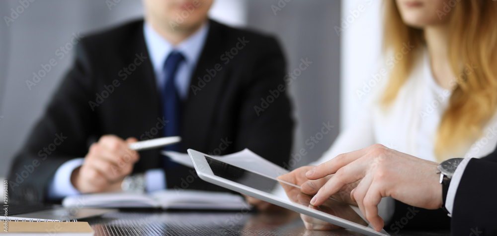 Business people or lawyers discussing questions of contract at meeting in modern office, close-up. Unknown businessman and woman with colleague sitting and working at the glass desk. Teamwork and