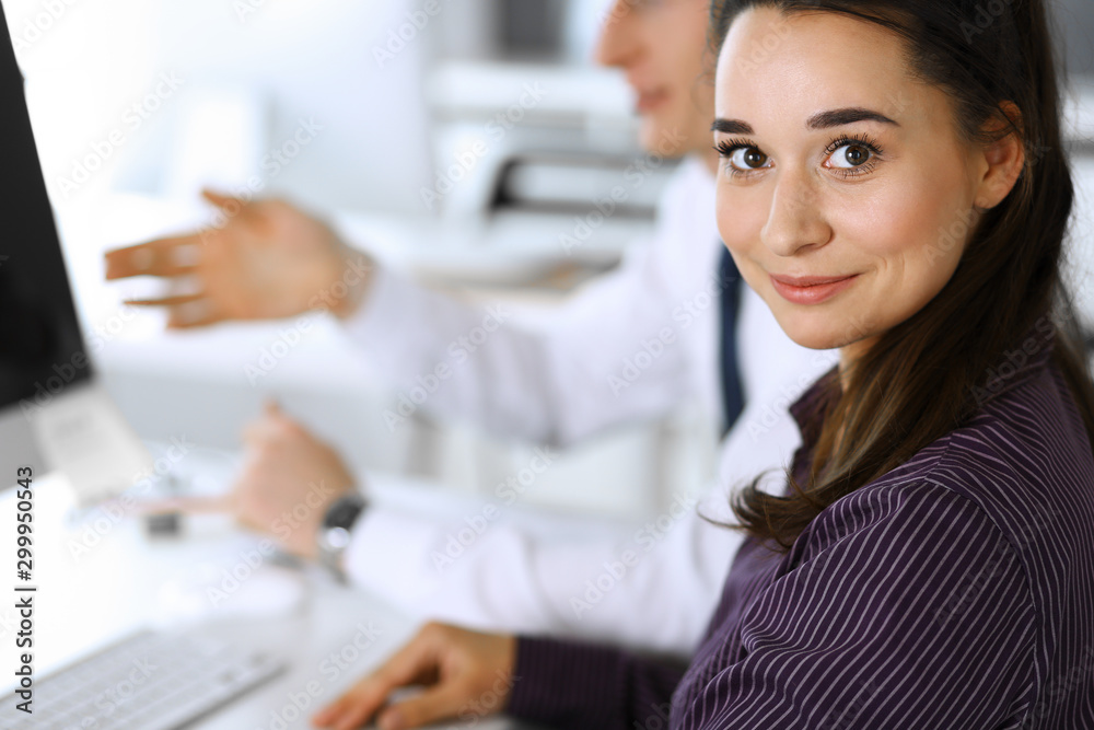 Business woman and man discussing questions while using computer at workplace in modern office. Teamwork, meeting and brainstorming concept Business woman and man discussing questions while using computer at workplace in modern office. Teamwork, meeting and brainstorming concept