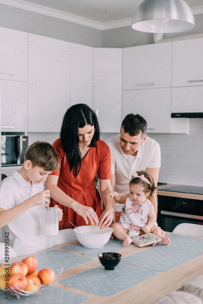Young family preparing food in kitchen at home