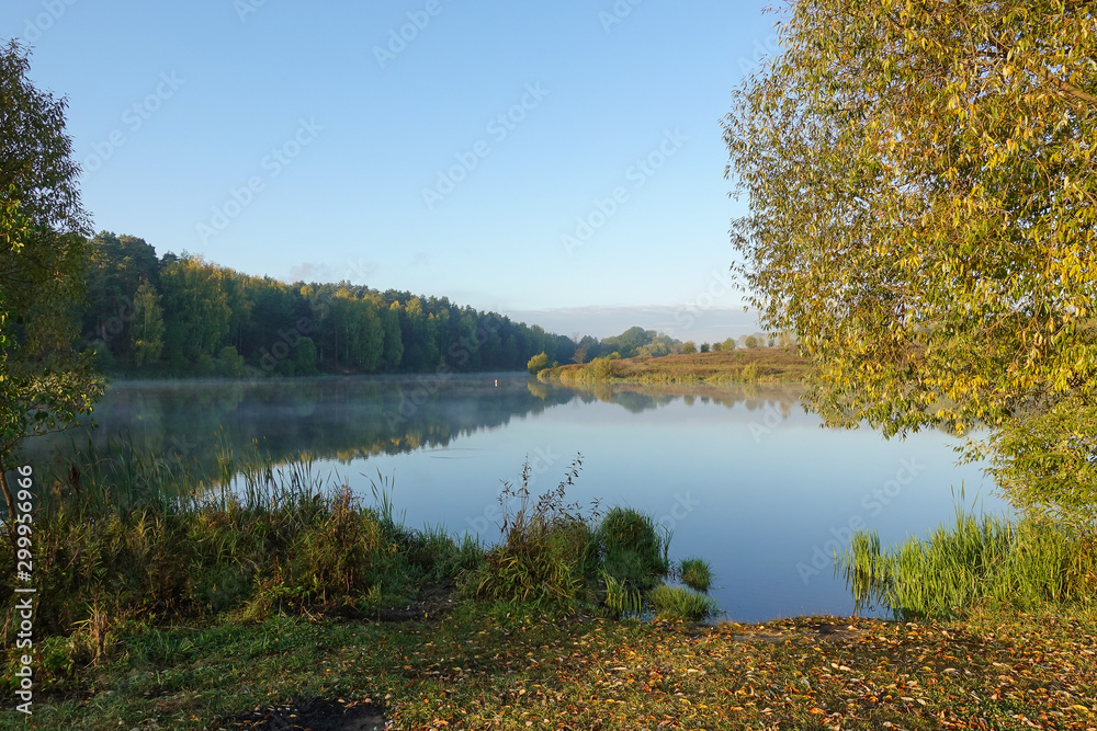 Beautiful Autumn scene with trees reflected in smooth lake