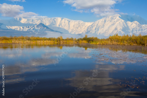 snowbound mountain ridge and small blue lake in a valley