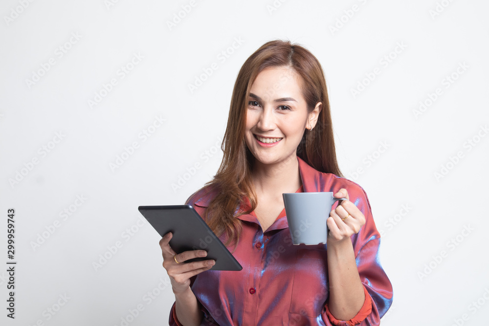Young Asian woman with a computer tablet and coffee. Young Asian woman with a computer tablet and coffee.
