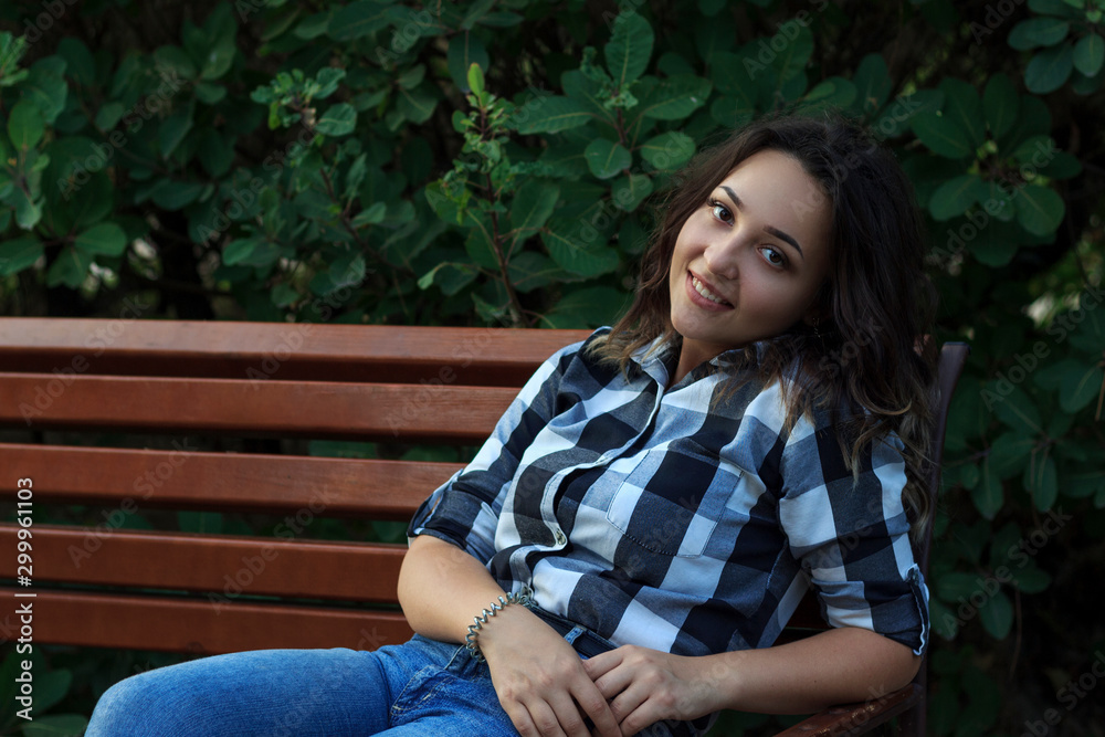 Obraz premium girl sitting on a bench, leaning her head against the back 