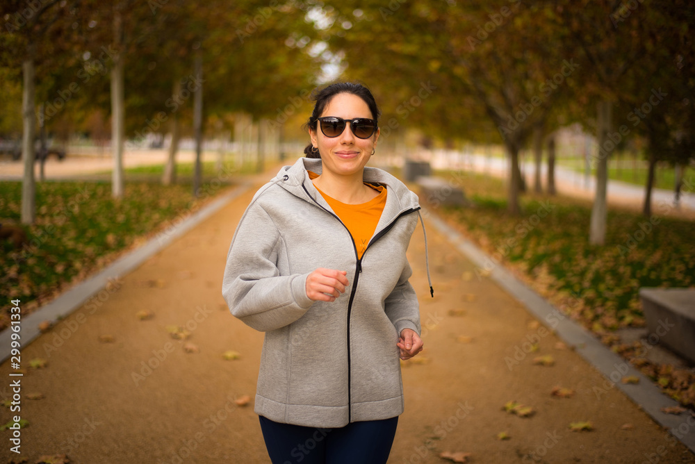 Mujer con gafas de sol corriendo en un parque en otoño foto de Stock |  Adobe Stock