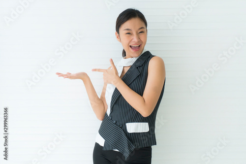 Asian beautiful young woman smile presenting with one hand on upper right side empty and left hand pointing. looking at camera in studio Isolated on white background. Advertisement& presentation conce