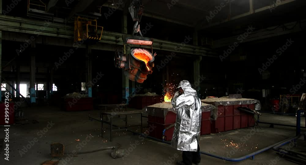 Hard work in a foundry. Metal smelting furnace in steel mill. Molten metal pouring, metallurgy, steel casting foundry. Steel manufacturing Hard work in a foundry. Metal smelting furnace in steel mill. Molten metal pouring, metallurgy, steel casting foundry. Steel manufacturing