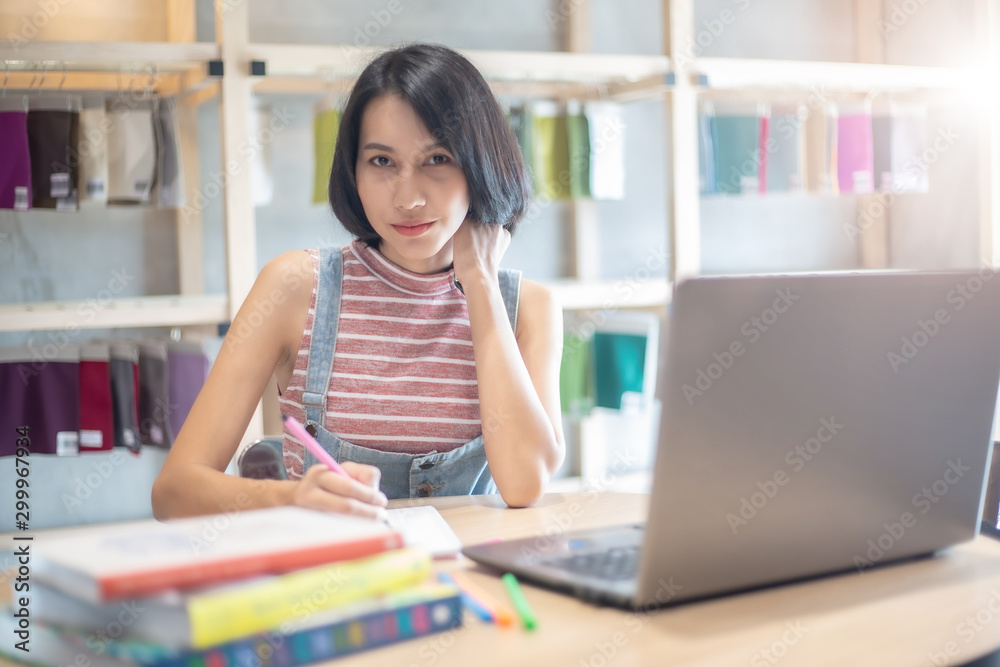 Young Asian woman using laptop computer and tablet PC to working in the modern co working space Young Asian woman using laptop computer and tablet PC to working in the modern co working space