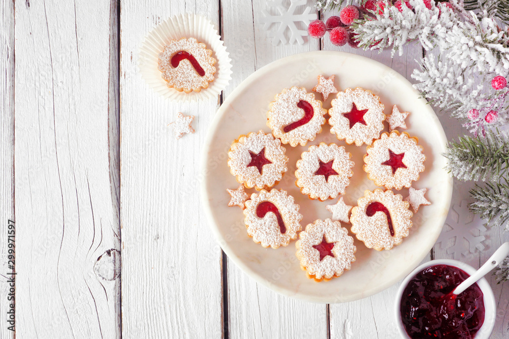 Christmas holiday Linzer cookies. Top view on a marble plate against a white wood background with copy space. Christmas holiday Linzer cookies. Top view on a marble plate against a white wood background with copy space.