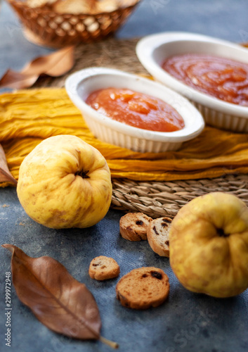 Quince Close up with a jelly quince in a white crockery containers and little toasts to spread.