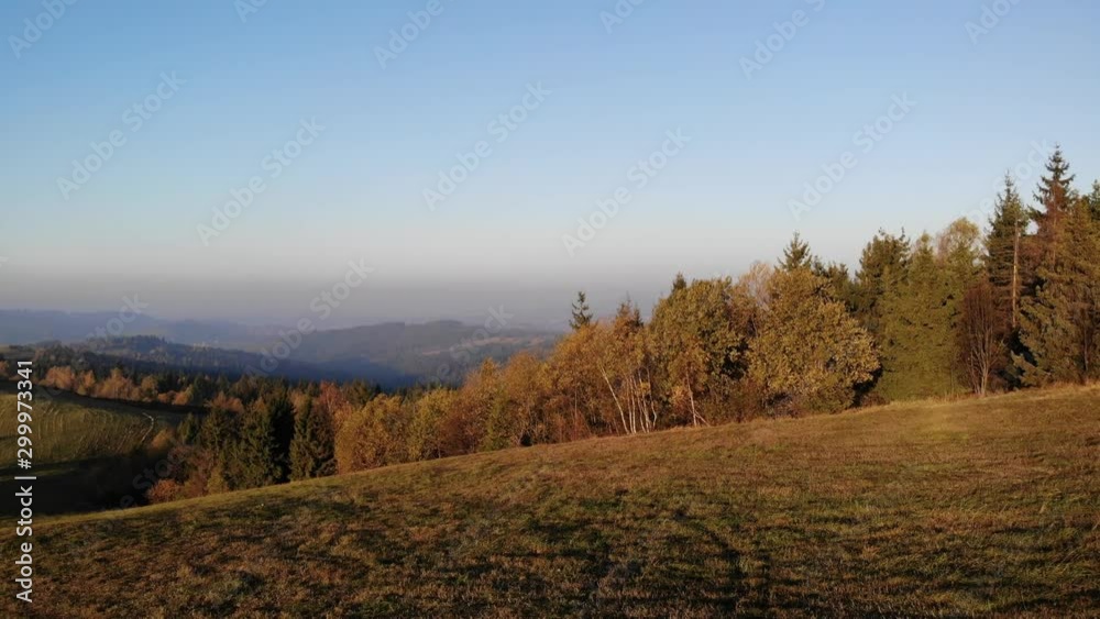 Flight over autumn mountains in the light of the setting sun.