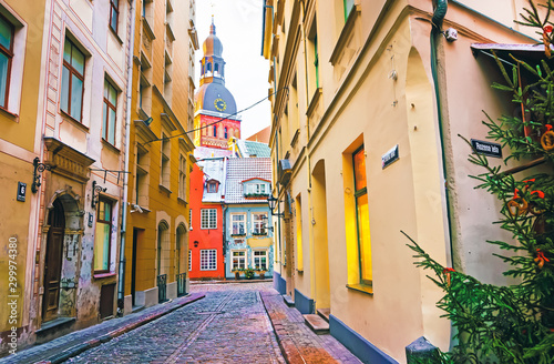 Foto Narrow street leading to St Peter church in Old Riga