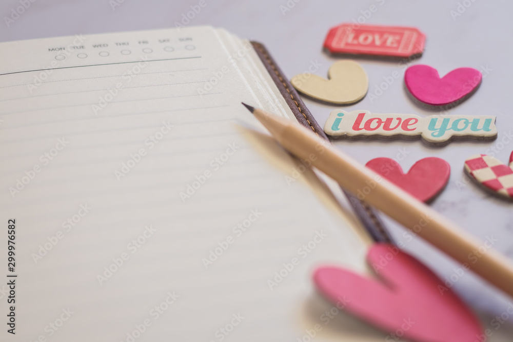 Blank or plain notebook, sharp pencil and lovely hearts with copy space. Conceptual realtionship of romance couple or lover, family, friends, happiness together. Love photo frame and valentine concept Blank or plain notebook, sharp pencil and lovely hearts with copy space. Conceptual realtionship of romance couple or lover, family, friends, happiness together. Love photo frame and valentine concept