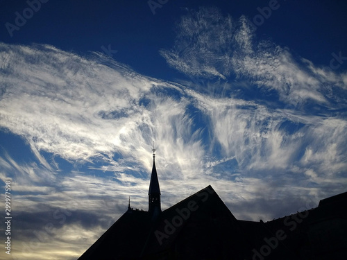 wispy clouds behind church
