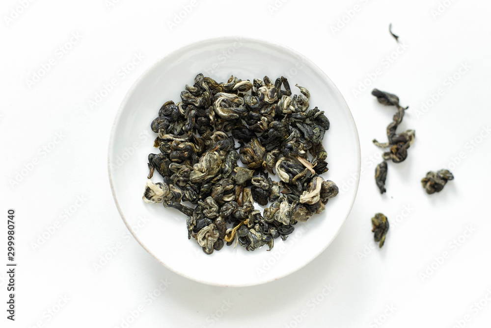 Fototapeta premium Dried green tea leaves on white background