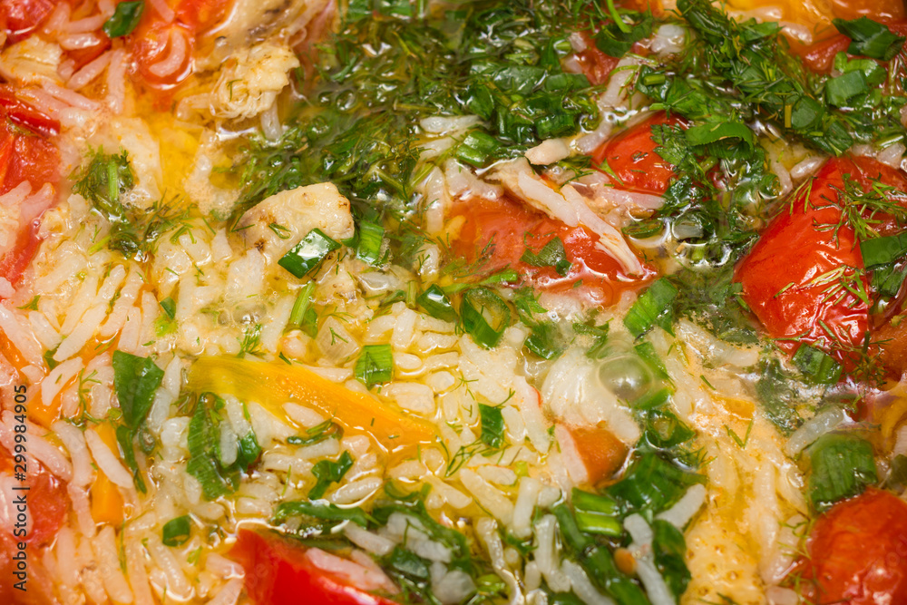 Abstract food cooking background. Boiling vegetables, rice and chicken meat pieces in bouillon closeup. Abstract food cooking background. Boiling vegetables, rice and chicken meat pieces in bouillon closeup.