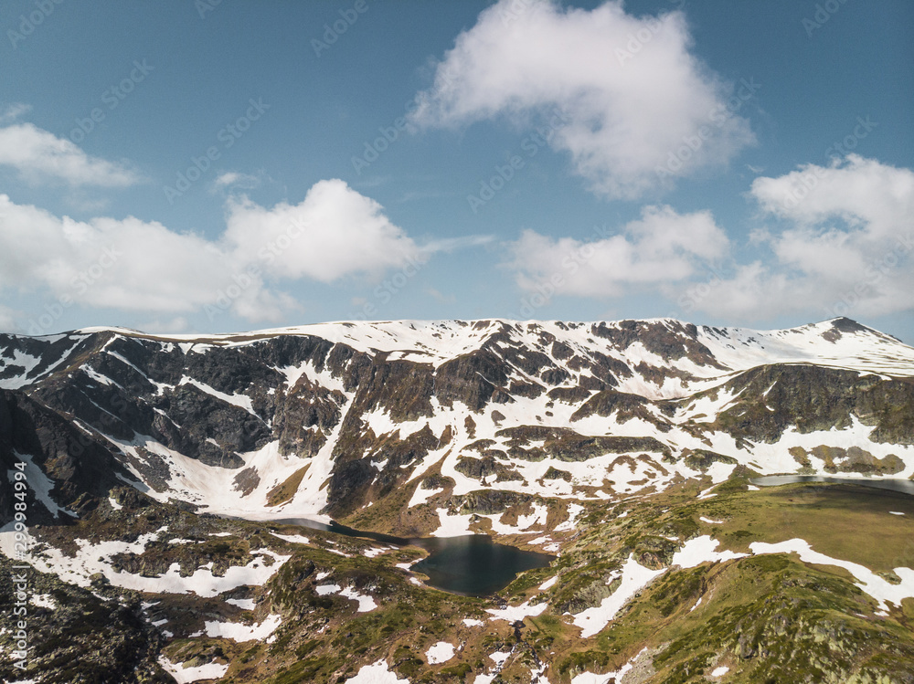 Aerial panoramic view of Seven Rila Lakes covered in snow during early summer day near in Rila Mountain (near Sofia, Bulgaria, Europe)