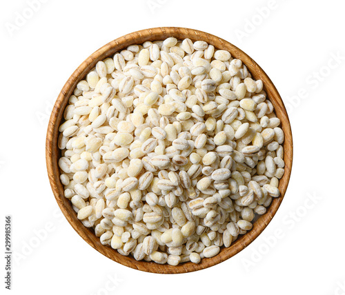 Pearl barley grains heap in wooden bowl close up isolated on white background photo