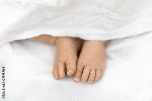 Little newborn feet on a white background, closeup of barefoot
