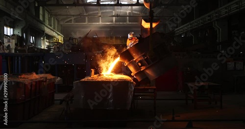 Hard work in a foundry. Metal smelting furnace in steel mill. Molten metal pouring, metallurgy, steel casting foundry. Steel manufacturing photo