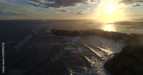 Aerial shot of the sunrise in the north coast of Spain with big waves. photo