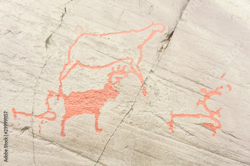 Rock art in Alta Fjord, Norway. Ancient symbols, real drawing, texture in stone. Red ocher paint. Human preys on animals deer. Group of petroglyphs, dating from c. 4200 to 500 B.C.