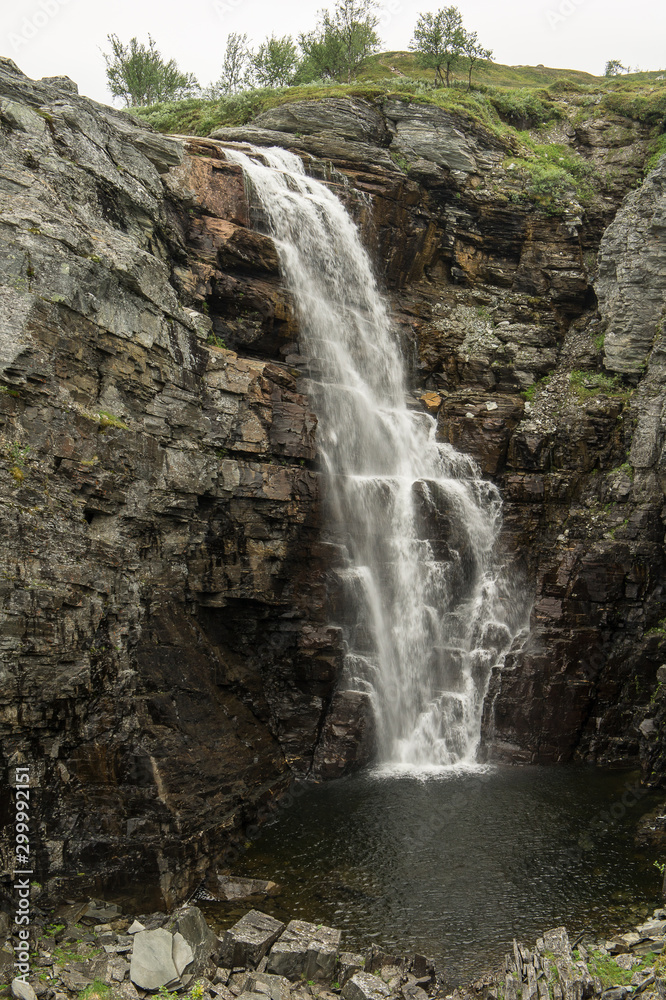 Mountain river and trees landscape natural environment. Hiking in the north of Europe. Natural waterfalls in Norway