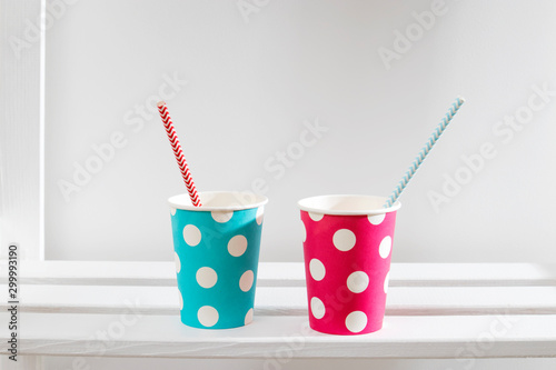 the blue and pink polka dot paper cups on white shelf in the kitchen cabinet