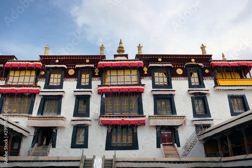 View of the front yard of the Drepung Monastery in Lhasa  Tibet  with white walls against a blue sky.